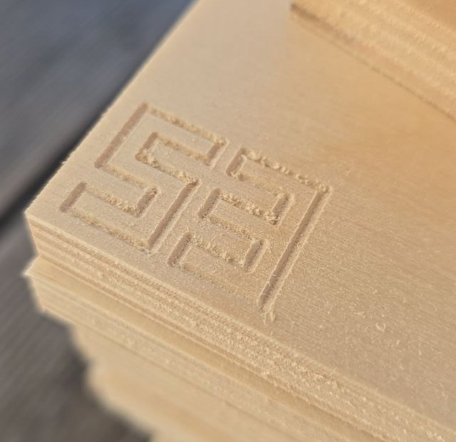 A stack of CNC-cut plywood slats with the number 58 engraved on the top part.